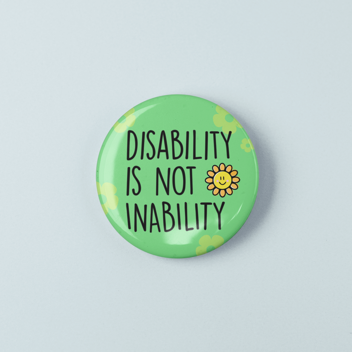 Button badge with 'Disability is not inability' text and a sunflower on a light blue background