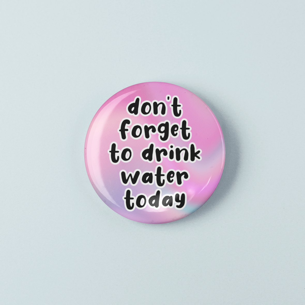 Button badge with 'don't forget to drink water today' text on a gradient pink and purple background