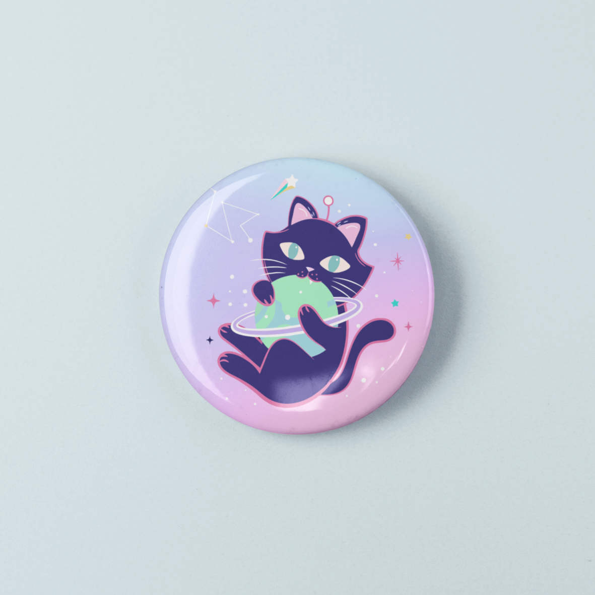 Circular button badge with a black cat holding a green shirt on a light blue background