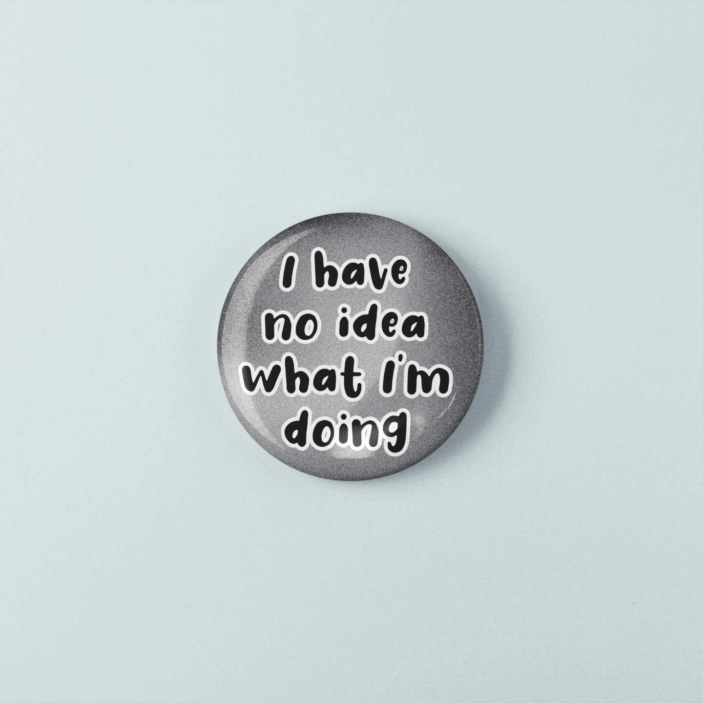 Round metal badge with 'I have no idea what I'm doing' text on a light blue background