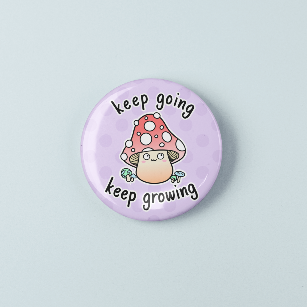 Button badge with mushroom illustration and 'keep going, keep growing' text on a light purple background