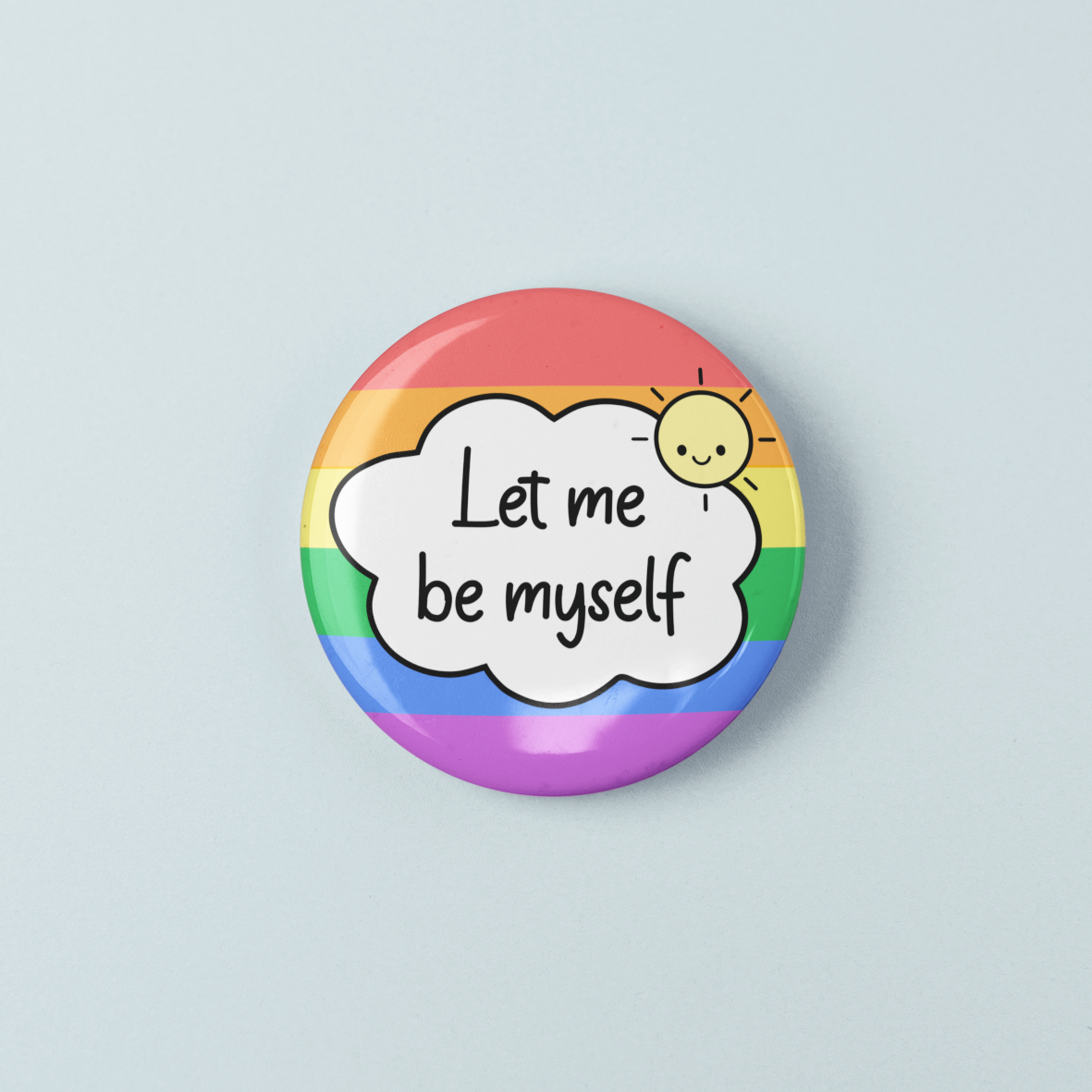 Button badge with rainbow border and 'Let me be myself' text on a light blue background