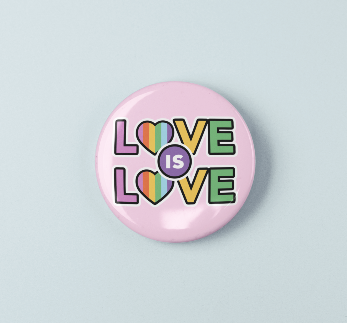 Pink button badge with 'LOVE IS LOVE' text in colorful letters on a light blue background