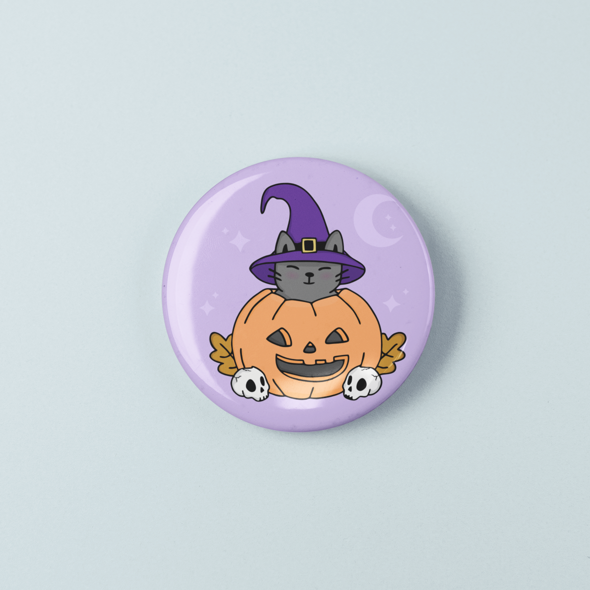 Halloween-themed button badge with a cat in a witch hat on a pumpkin against a light purple background