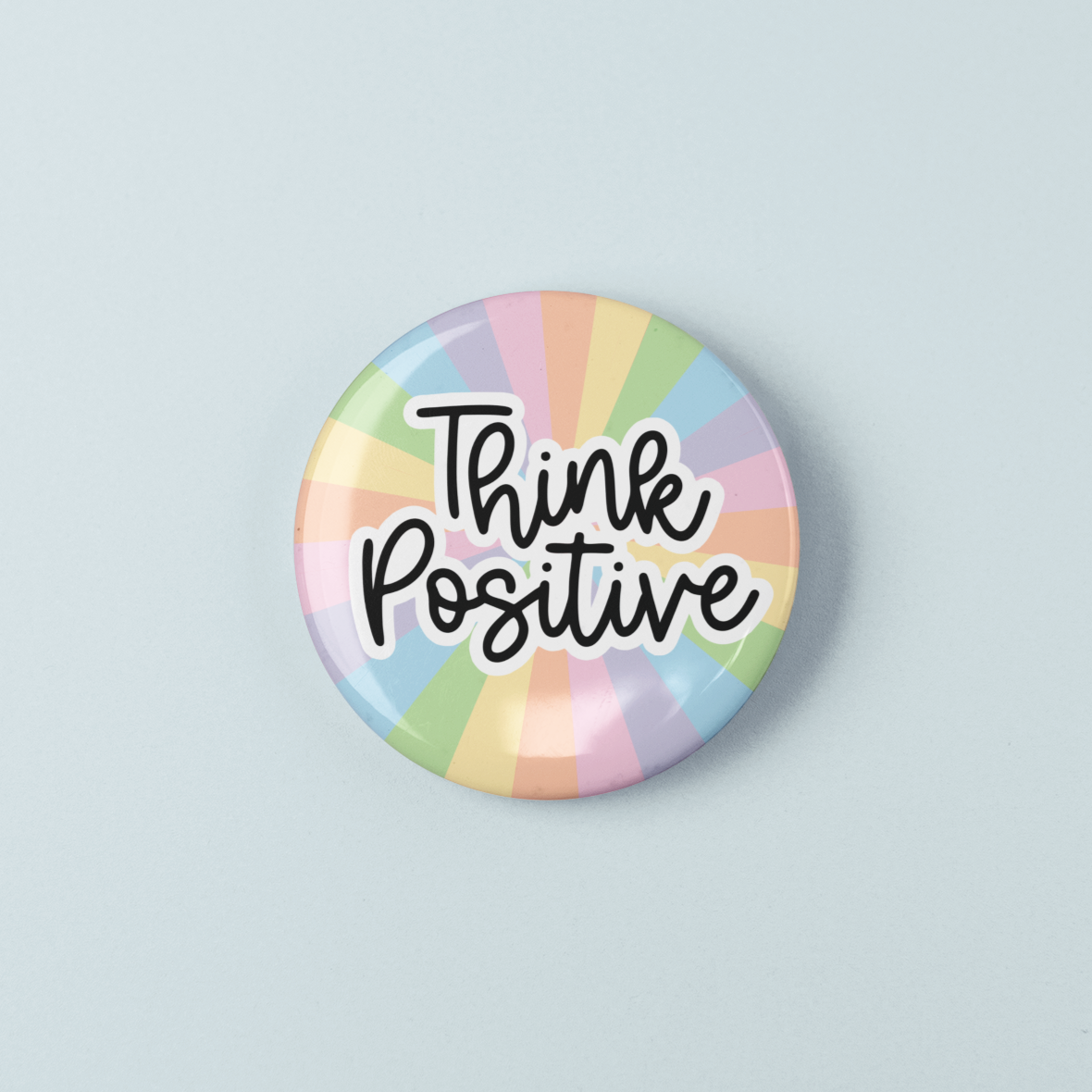 Button badge with 'Think Positive' text on a pastel rainbow background