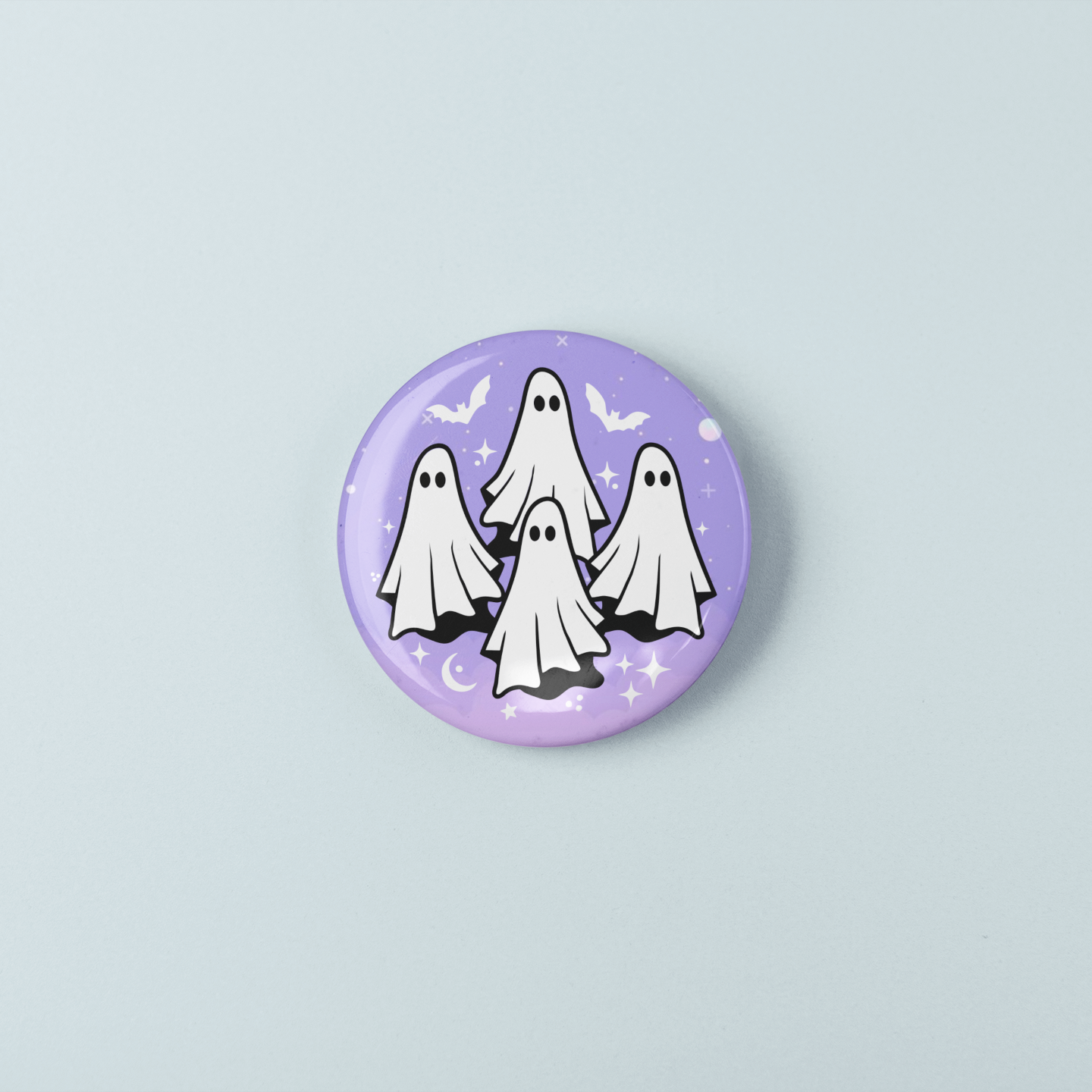Button badge with cartoon ghosts on a light purple background