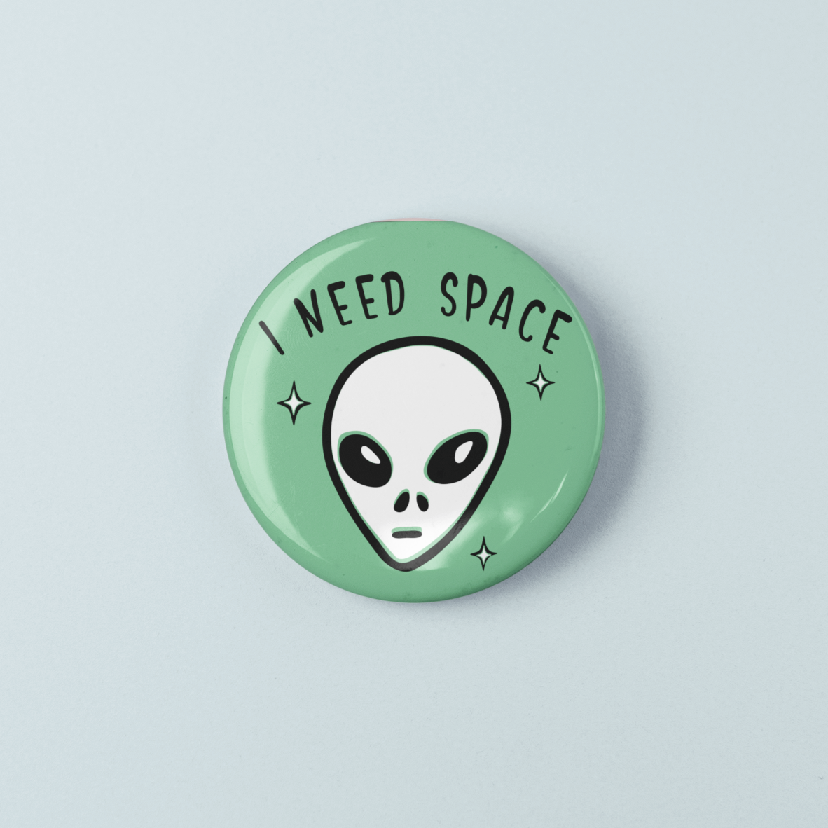 Button badge with alien face and 'I Need Space' text on a light green background
