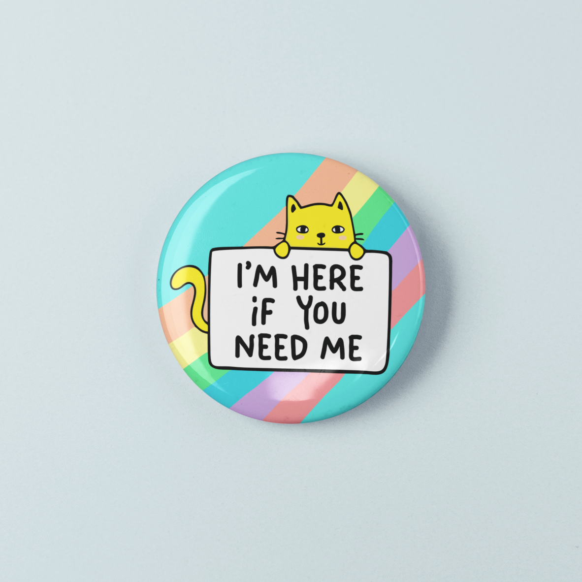Button badge with a cat illustration and text 'I'm here if you need me' on a rainbow striped background.
