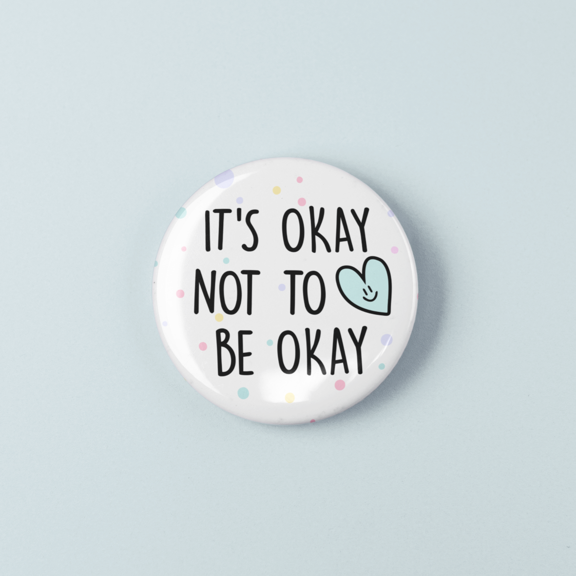 Button badge with 'It's okay not to be okay' text on a light blue background