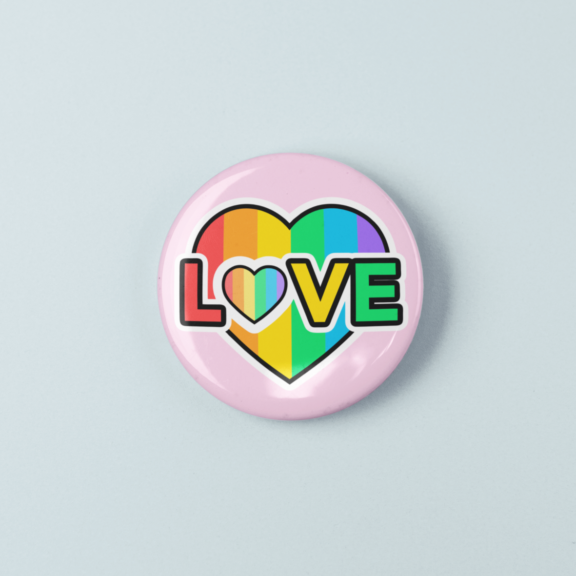Button badge with rainbow heart and 'LOVE' text on a light gray background