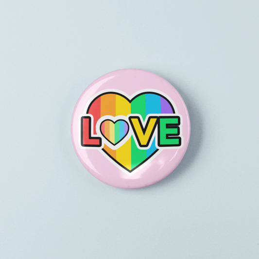 Button badge with rainbow heart and 'LOVE' text on a light gray background