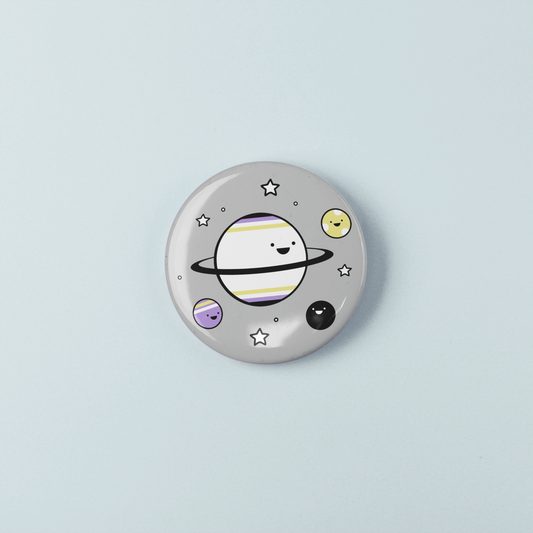 Button badge with a cartoon planet design on a light blue background