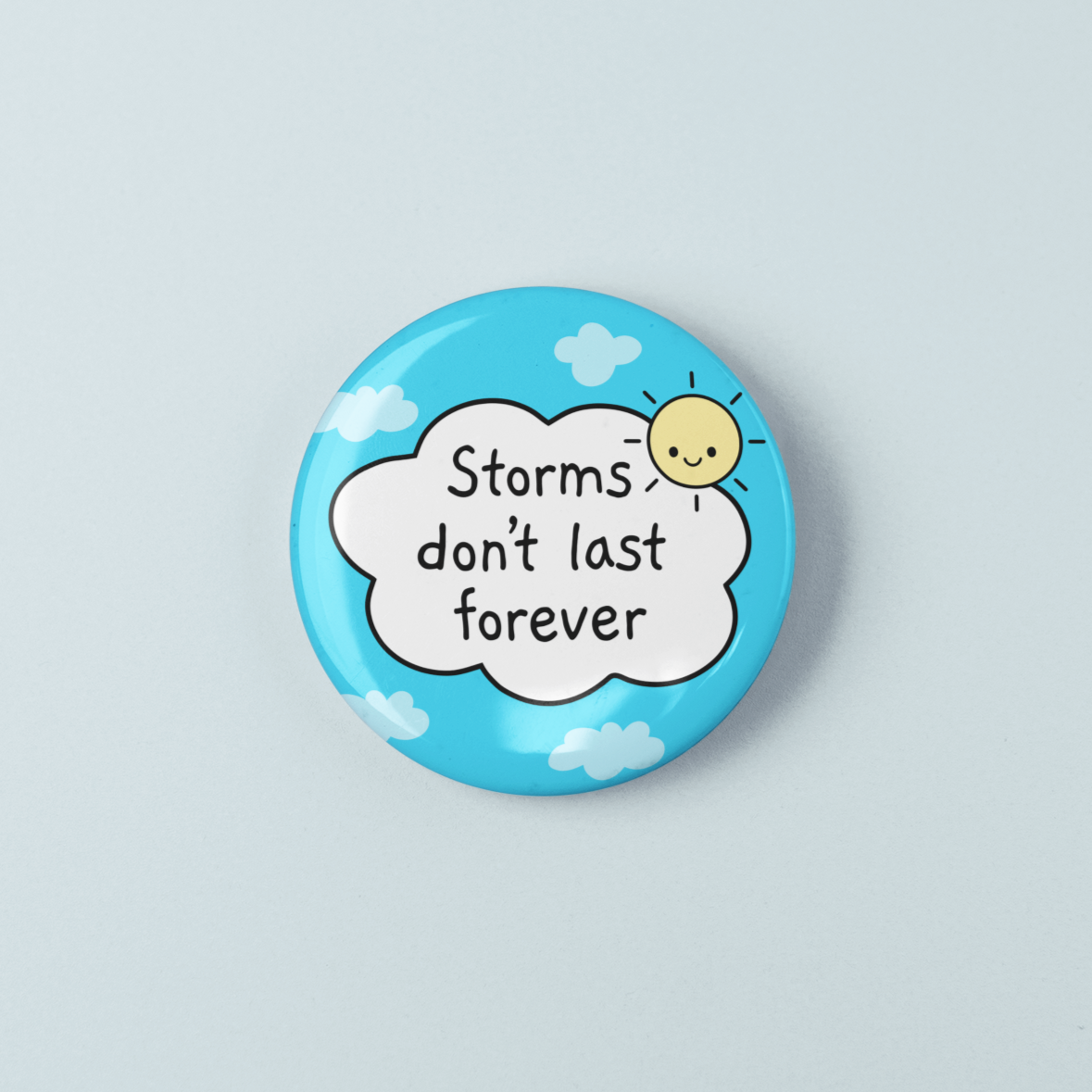 Button badge with 'Storms don't last forever' text on a light blue background