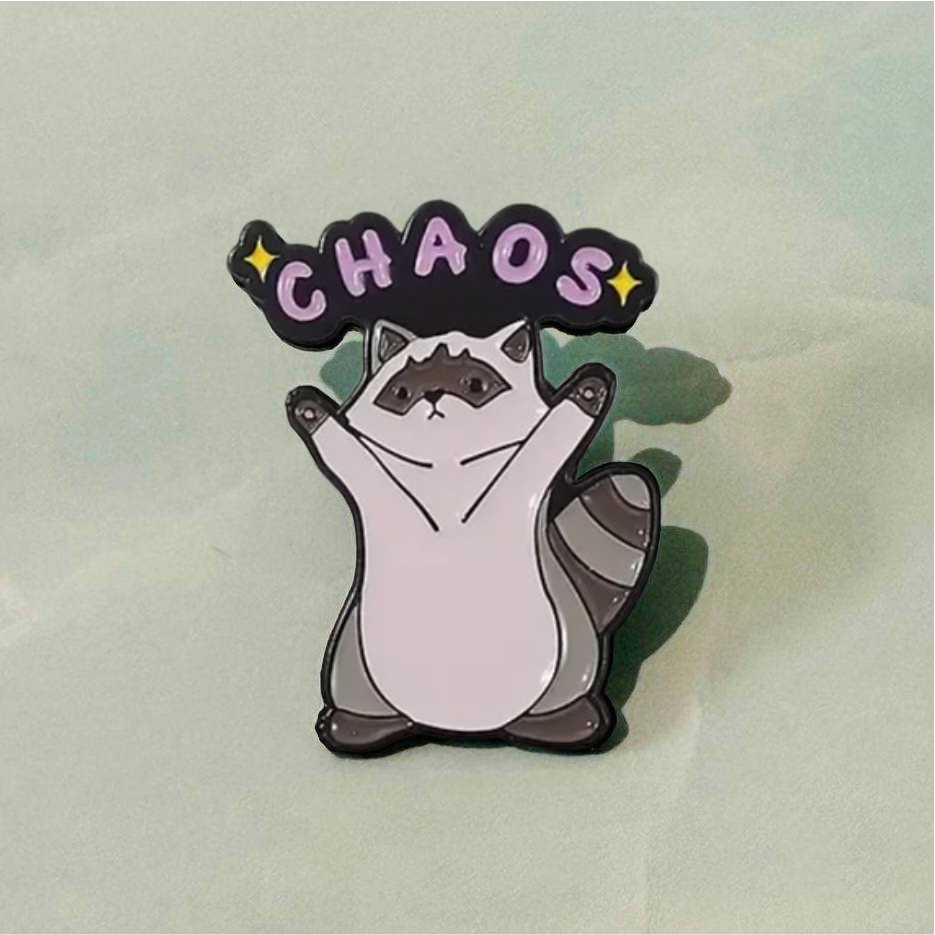 Enamel pin with a cat design and 'CHAOS' text on a light background