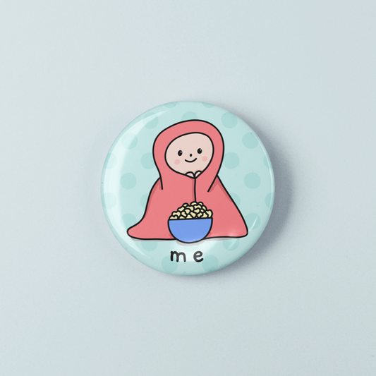 Button badge with a cartoon character holding a bowl labeled 'me' on a light blue background