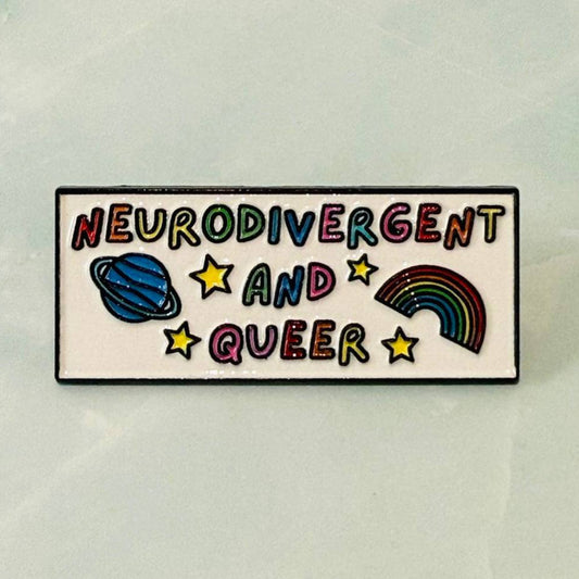 Enamel pin with 'Neurodivergent and Queer' text and symbols on a light background